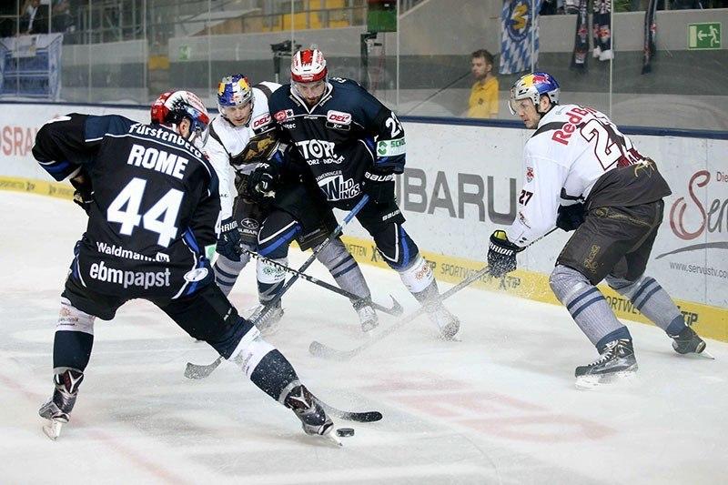 Schwenningens 44 Ashton Rome kann den Puck gegen Muenchens 27 Matt Smaby und 12 Mads Christensen behaupten